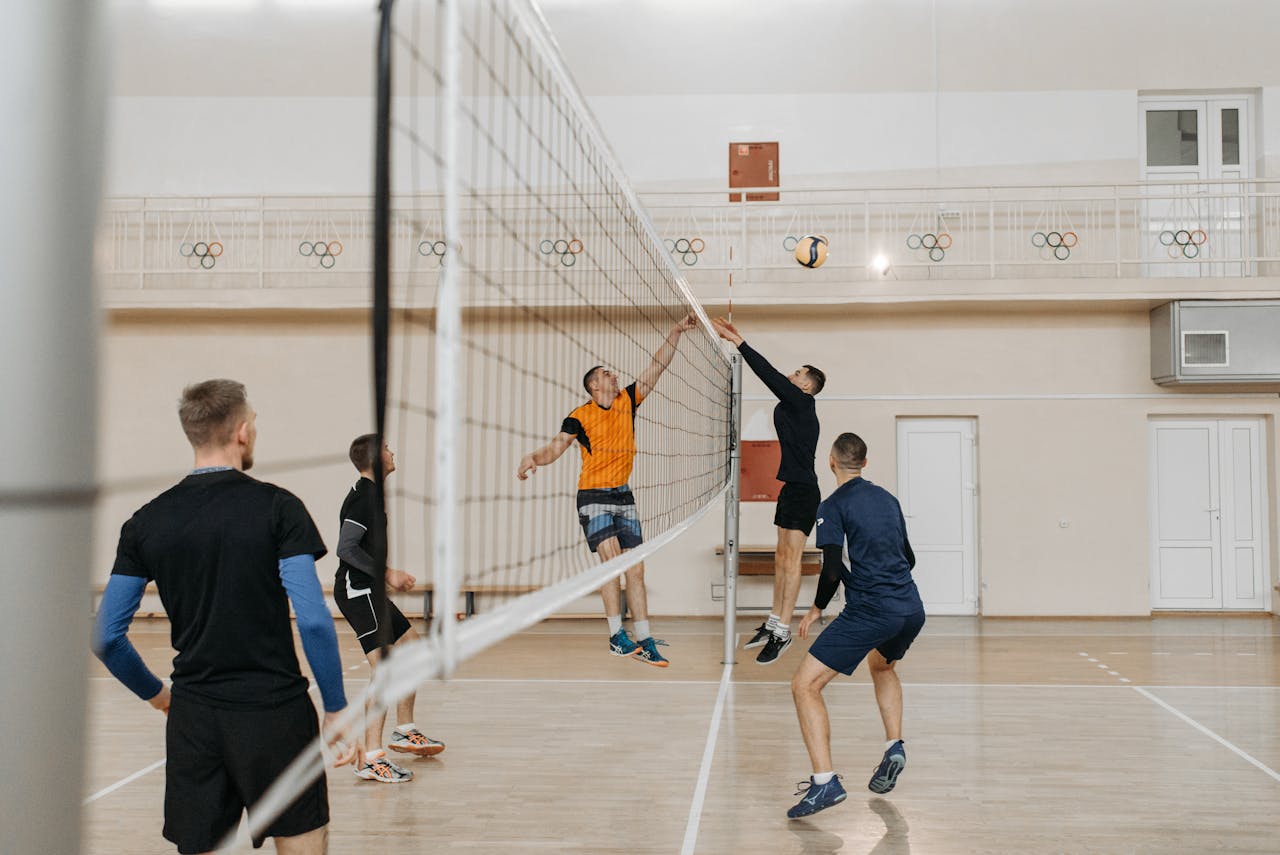 Mastering the First Impression: Your intriguing post title goes here Exciting indoor volleyball match with athletes jumping to block and spike.