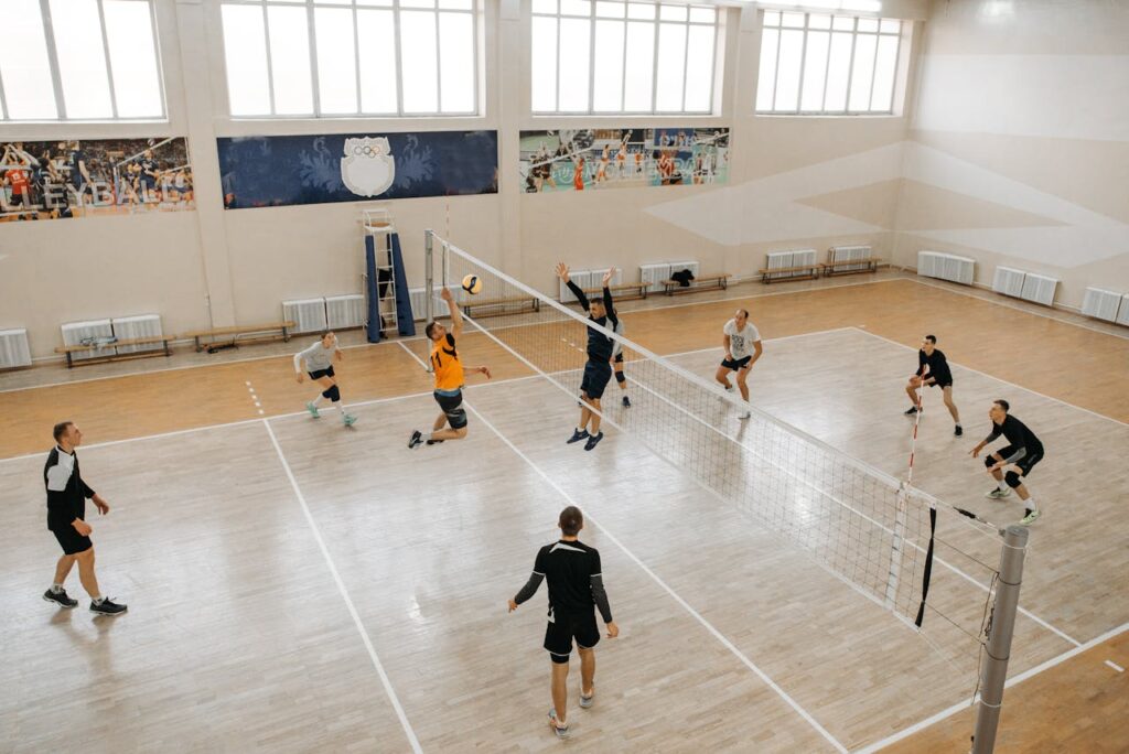 High-energy indoor volleyball game with teams competing intensely on the court.
